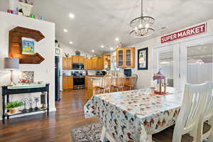 Dining room featuring lofted ceiling, a chandelier, and dark hardwood / wood-style flooring