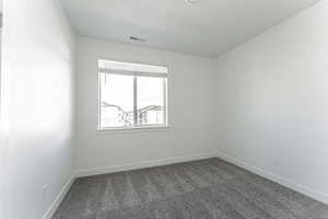 Unfurnished room with dark carpet and a textured ceiling