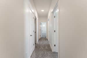 Corridor featuring carpet flooring