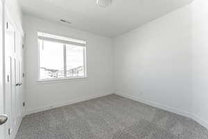 Spare room with a textured ceiling and carpet flooring