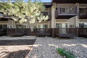 Back of property featuring a balcony and a wooden deck