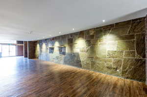 Unfurnished room featuring tile walls and hardwood / wood-style floors