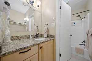 Bathroom featuring  shower combination, tile patterned flooring, and vanity