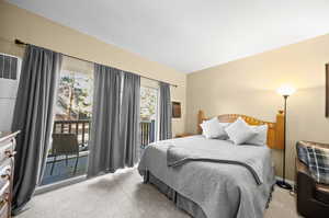 Carpeted bedroom featuring multiple windows and access to outside