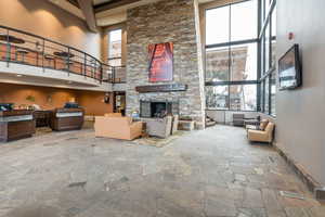 Living room featuring a high ceiling and a stone fireplace