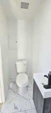 Bathroom featuring toilet, tile patterned flooring, and vanity