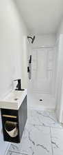 Bathroom with tile patterned flooring, a shower, and vanity