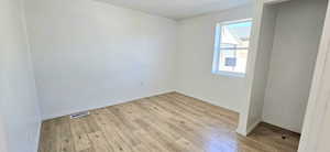 Empty room with light hardwood / wood-style floors and a textured ceiling