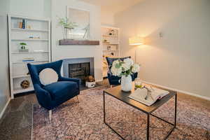 Sitting room with carpet and a fireplace