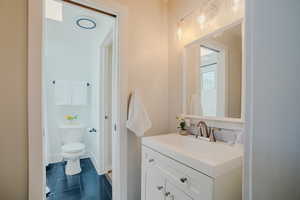 Bathroom featuring tile patterned flooring, vanity, and toilet