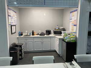 Kitchen featuring sink, white cabinetry, and refrigerator