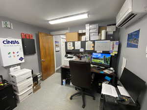 Office with an AC wall unit and electric panel