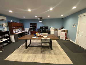 Office area with a wall mounted AC and concrete flooring