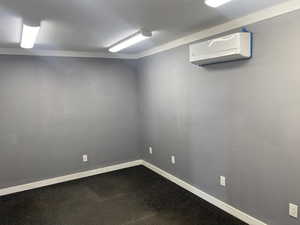 Carpeted spare room featuring a wall unit AC