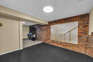 Basement featuring brick wall and matted floor