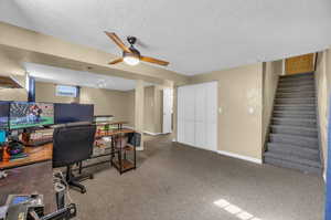 Family room featuring a ceiling fan, carpet, and a textured ceiling