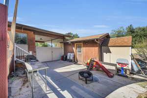 View of patio, storage shed and work shop shed with power