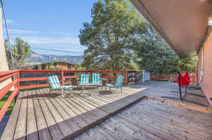 Wooden deck with a mountain view, stone wall,