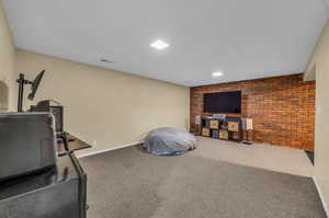 Master bedroom with carpet floors and brick wall