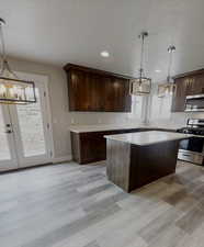 Kitchen with sink, decorative light fixtures, a wealth of natural light, and appliances with stainless steel finishes