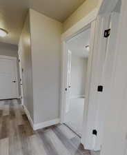 Corridor featuring light hardwood / wood-style flooring and a textured ceiling