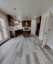 Kitchen featuring a wealth of natural light, a kitchen island, pendant lighting, and appliances with stainless steel finishes