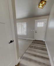 Entrance foyer featuring a textured ceiling and light wood-type flooring