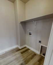 Laundry room with electric dryer hookup, washer hookup, and light hardwood / wood-style floors