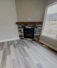 Interior details featuring wood-type flooring and a stone fireplace