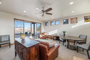 Carpeted living room featuring ceiling fan