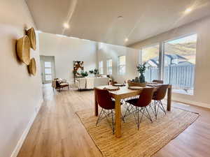 Dining area with a towering ceiling and light wood-type flooring