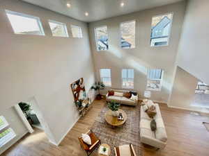 Living room featuring light hardwood / wood-style flooring and a towering ceiling