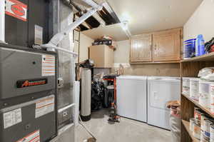 Laundry room with washing machine and dryer, heating unit, and cabinets