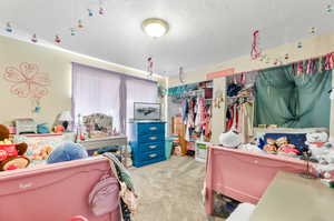 Carpeted bedroom featuring a closet and a textured ceiling