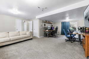 Carpeted office space with a textured ceiling