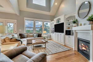 Living room with light hardwood / wood-style floors, high vaulted ceiling, and plenty of natural light   Amazing Views of the mountains!