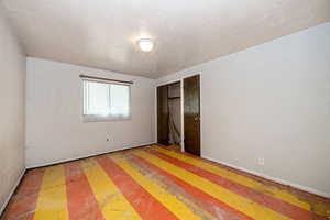 Unfurnished bedroom with a closet and a textured ceiling