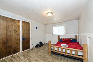 Bedroom featuring a textured ceiling, two closets, and tile flooring