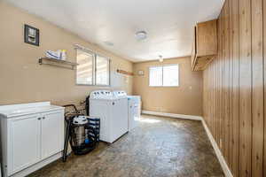 Laundry room with laminate flooring, a textured ceiling, sink vanity, and independent washer and dryer. Drain and water lines in place for the sink--needs to be hooked up.