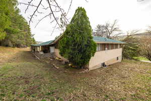 View of side of home featuring brick siding and metal roof