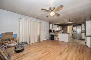 Dining area featuring ceiling fan, hardwood flooring, and a textured ceiling