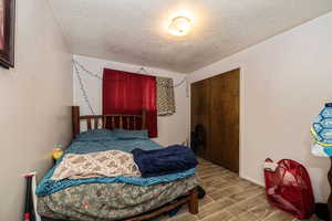 Bedroom with a closet. tile flooring, and a textured ceiling