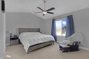 Primary Bedroom with ceiling fan, vaulted ceiling, and light carpet