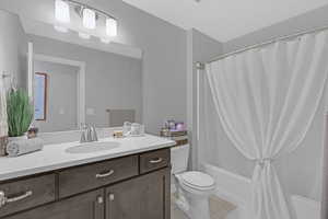 Full bathroom featuring shower / bath combination, tile patterned floors, toilet, and vanity