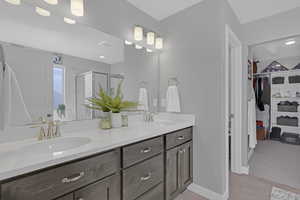 Primary Bathroom with tile patterned flooring, a shower with door, and vanity with double sinks