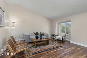 Living room with dark hardwood / wood-style floors and lofted ceiling