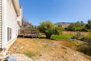 View of yard featuring a deck with mountain view