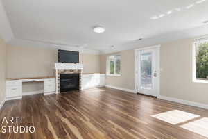 Unfurnished living room with a fireplace and dark wood-type flooring