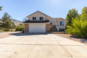 View of front of house with a mountain view and a garage