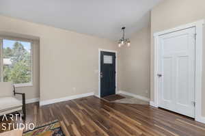 Foyer with a notable chandelier and dark hardwood / wood-style flooring